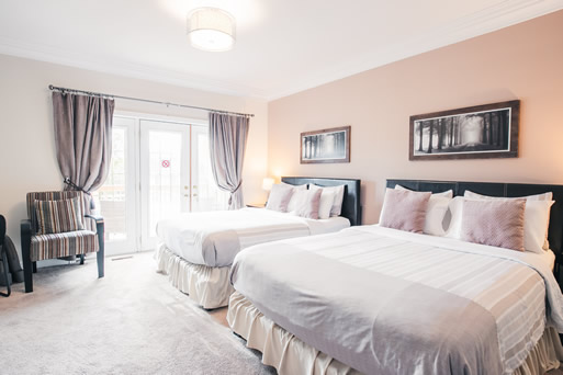 Blossom Room - Main level. Features 2 queen beds, bath tub, fridge, balcony, smart TV and desk. $180.80 incl. H.S.T. (2 persons - $25.00 extra charge for 3rd and 4th person)